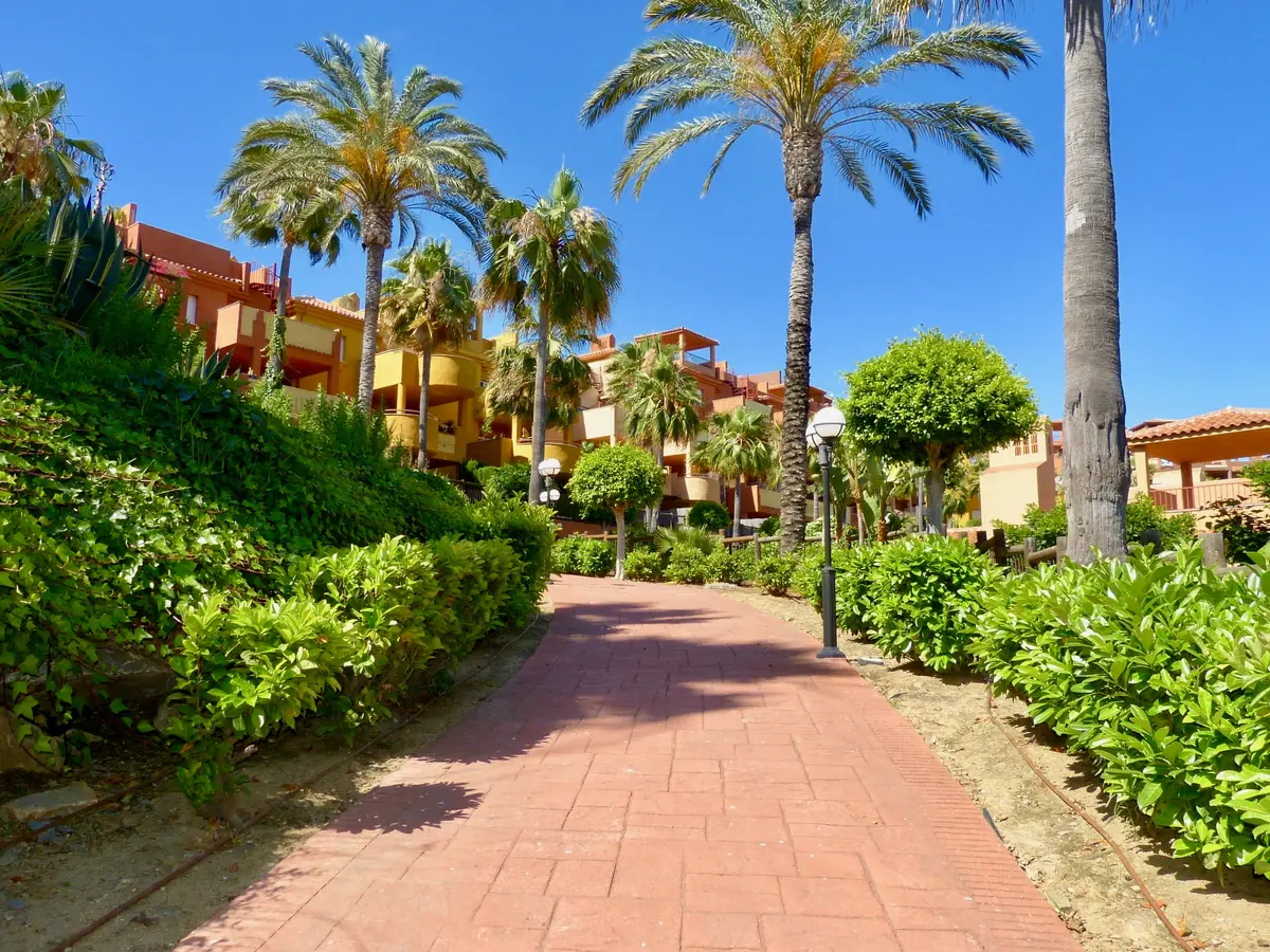 Paseo entre jardines y palmeras de La Reserva de Marbella